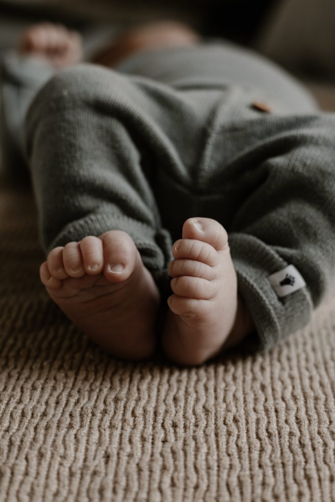 kleine voetjes van een pasgeboren baby die symbool staat voor kwetsbaarheid na de bevalling